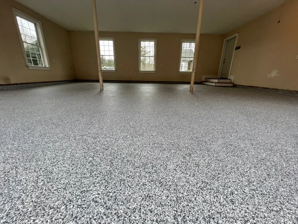 Empty room with shiny epoxy flooring and multiple windows allowing natural light